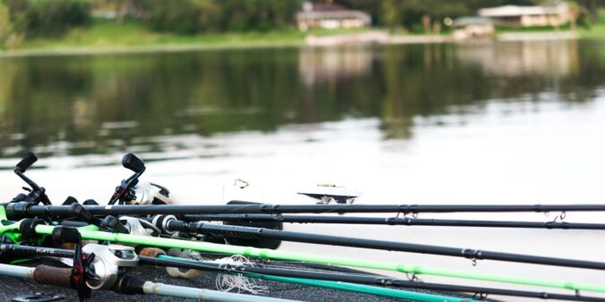 a group of fishing rods sitting next to a body of water