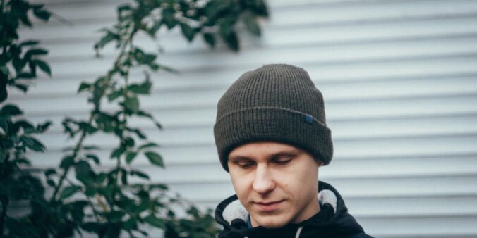 man standing near green plant